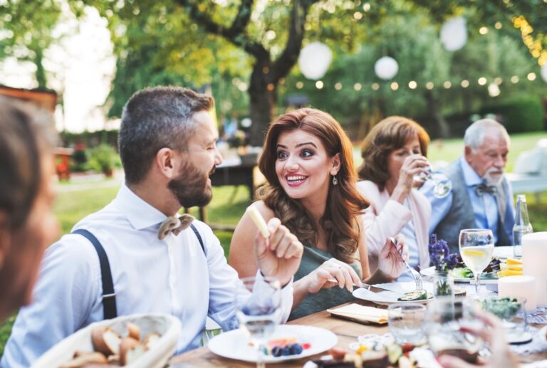 People outside enjoying a meal in a yard.
