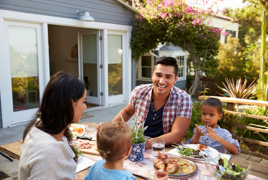 Family in backyard of house having a meal